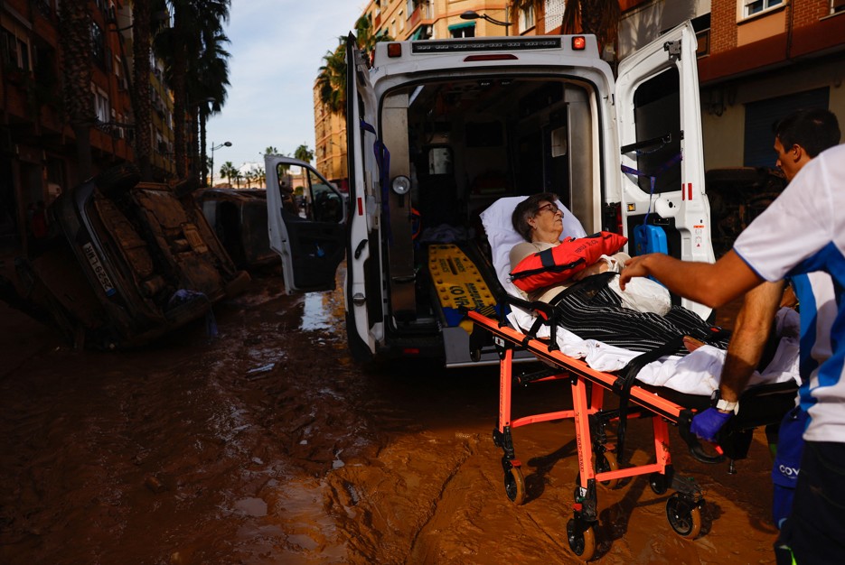 Mulher é transportada para uma ambulância depois de temporal na Espanha