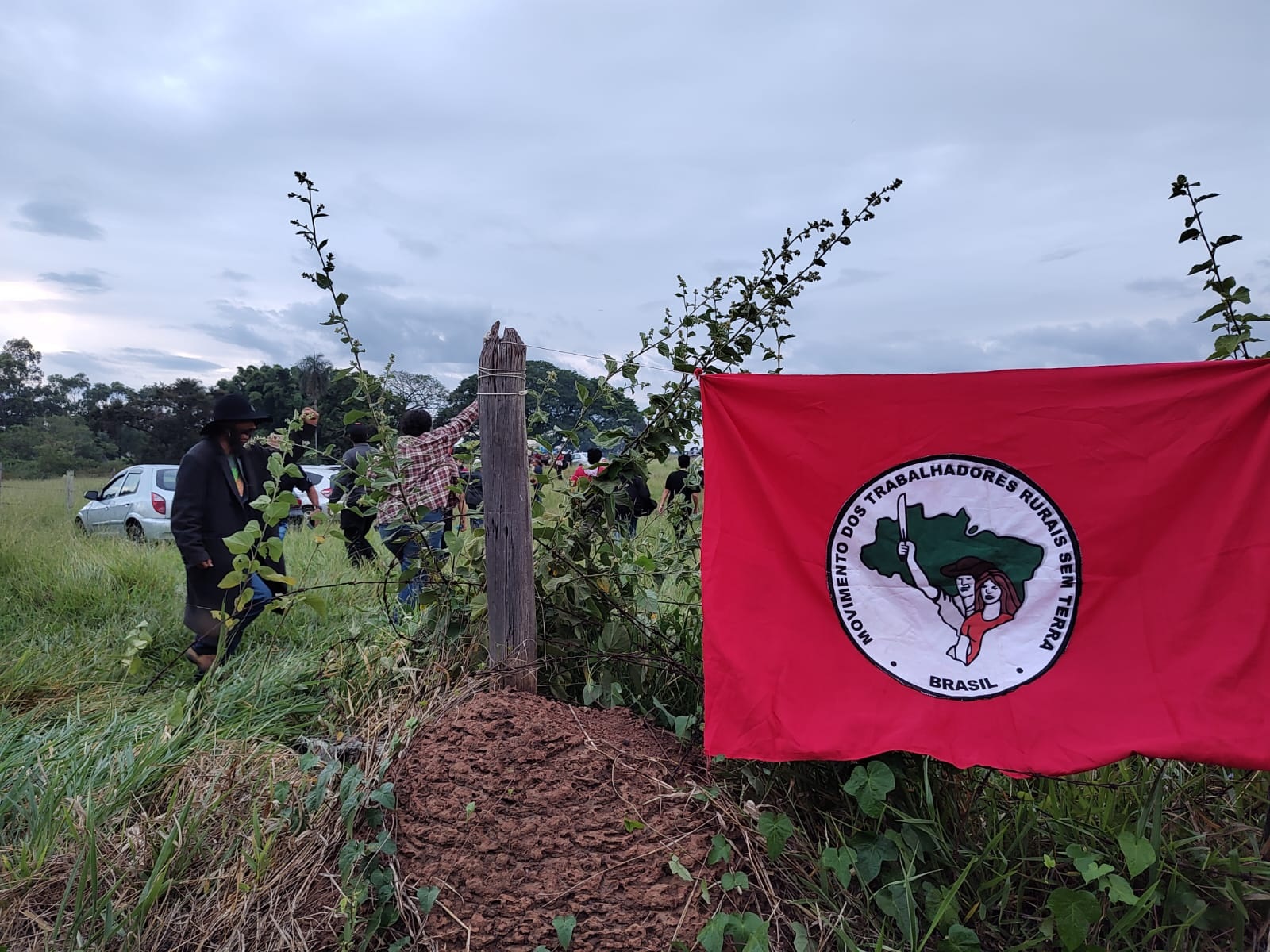 Bandeira do MST estendida em uma cerca